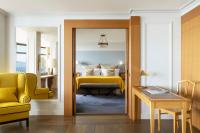a bedroom with a yellow bed and a yellow chair at Hôtel Royal in Évian-les-Bains