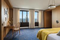 a hotel room with a bed and a desk and a window at Hôtel Royal in Évian-les-Bains