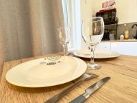 a wooden table with two plates and two wine glasses at AuKabest 3 * Proche ferry * Gare in Calais