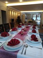 a long table with white plates and red napkins at Hotel Villa Golf Cihelny in Karlovy Vary