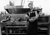 Un hombre en una cocina sosteniendo un tazón en Yxningens Holiday Homes, Cottages and Camping, en Gusum