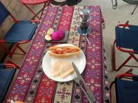 a table with a plate with a sandwich and a knife at Ha Giang Yolo House and Loop Tours in Ha Giang