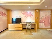 a room with a desk with a tv and paintings on the wall at JinShan Sakura Bay Hot Spring Hotel in Jinshan