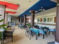 Un comedor con mesas y sillas azules. en AM Surin Place, en Surin Beach