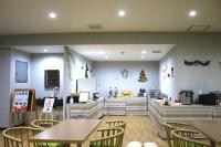 un restaurant avec des tables et des chaises en bois et des décorations de Noël dans l'établissement ホリディパールホテル, à Osaka