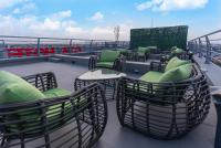 patio z krzesłami i stołami na dachu w obiekcie GTA HOTEL IKEJA w mieście Ikeja