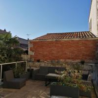 a patio with furniture and plants on a brick wall at L Appart des Cloutiers in La Rochelle
