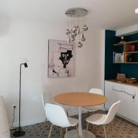 a dining room with a table and white chairs at L Appart des Cloutiers in La Rochelle