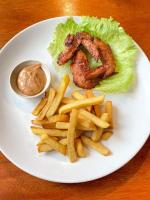 a plate of food with fried chicken and french fries at Alwi Villa Gili Trawangan in Gili Trawangan