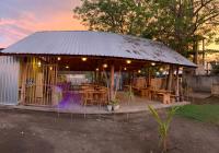 a pavilion with wooden tables and chairs in a park at Alwi Villa Gili Trawangan in Gili Trawangan