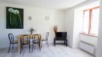 a dining room with a table and chairs and a television at Auberge Les Grillons in Meyras