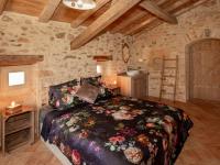 a bedroom with a bed in a room with stone walls at Rustic holiday home in Loubejac with jacuzzi in Loubejac
