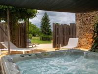 a hot tub in a yard with two chairs at Rustic holiday home in Loubejac with jacuzzi in Loubejac