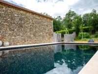 a swimming pool in front of a brick building at Rustic holiday home in Loubejac with jacuzzi in Loubejac