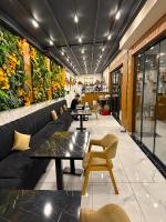 een restaurant met banken, tafels en planten aan de muur bij Mays Royal Hotel in Istanbul