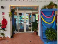 a store with a blue door with a smiley face at Le Cosy - Studio spacieux, équipé, proche Plage &amp; Piscine, au Manganao in Saint-François