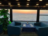 a table and chairs in a room with a view of the ocean at KENT hotel & Restaurant KENT beach in K'obulet'i
