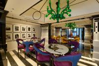 un comedor con sillas y mesas púrpuras y una lámpara de araña en Noah Sky Suites, en Kochi