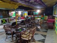 a restaurant with tables and chairs in a room at Bob Marley Peace hotel luxor in Luxor
