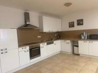 a kitchen with white cabinets and a stove top oven at Apartment am Schlosspark 3 in Cheb