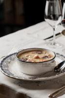 ビエラにあるHotel Aran La Abuelaのテーブルの上の皿の上にスープの入ったボウル