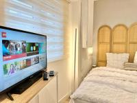 a bedroom with a large flat screen tv and a bed at Logement Entier au Centre Ville in Évreux