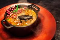 a pot of soup on top of a red plate at Colores de Purmamarca in Purmamarca