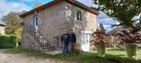 two people standing in front of a brick house at La ch&#39;tiote meizou in Mazet-Saint-Voy