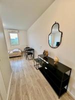 a living room with a black dresser and a mirror at Studio cosy - 15 minutes from Paris and CDG Airport in Le Blanc-Mesnil