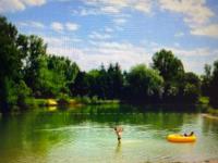 a person standing in a river with a raft at MOBIL HOME Clim BOOFZHEIM 6 PERSONNES 3 CHAMBRES LE RIED 3 ETOILES PROCHE EUROPA PARK in Boofzheim