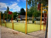 a yellow fence in front of a playground at MOBIL HOME Clim BOOFZHEIM 6 PERSONNES 3 CHAMBRES LE RIED 3 ETOILES PROCHE EUROPA PARK in Boofzheim