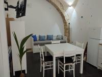 una mesa blanca y sillas en una cocina con sofá en &quot;In Fondo al Mar&quot; - Casa Vacanze, en Manfredonia