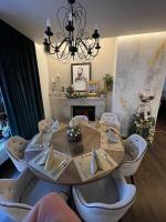 Un comedor con una mesa y sillas y una lámpara de araña. en Apartmán Rea, en Komárno