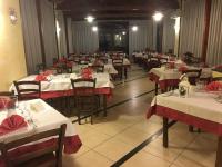 ein Esszimmer mit weißen Tischen und roten Servietten in der Unterkunft Agricampeggio Verde Etna in Aci SantʼAntonio