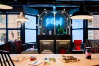 a table in a restaurant with a sign that reads play at Moxy The Hague in The Hague