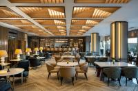 um restaurante com mesas, cadeiras e um bar em Hilton Tel Aviv Hotel em Tel Aviv