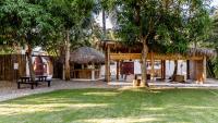 a park with a bench and a hut with trees at Kibayo Lagoon Villa in Cabarete