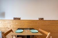 a wooden table with two plates and glasses on it at Bliss - Studio au pied des pistes in Villarembert
