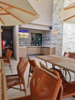 een restaurant met een tafel en stoelen en een bar bij Sunny Hall Acqua com piscina privativa in Porto De Galinhas