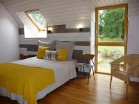 - une chambre avec un lit et une couverture jaune dans l&#39;établissement L&#39;ecurie, à Cohiniac