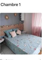 a bedroom with a bed with a blue quilt at Villa Imelda à saint André la réunion in Le Patelin