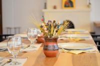 a table with a vase of flowers on a table with glasses at Casa de Oaspeți Sfântul Nicolae in Iaşi