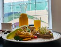 Un plato de comida en una mesa con un vaso de jugo de naranja. en La Quinta by Wyndham Reynosa, en Reynosa