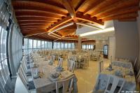 Un gran salón de banquetes con largas mesas y sillas. en Villa Clorè Hotel & Spa, en Lama Mocogno