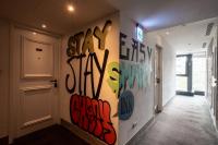 a hallway with graffiti painted on the wall at CHECK inn Taipei Songjiang in Taipei
