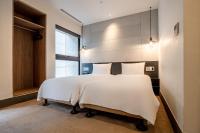 a bedroom with two beds with white sheets at CHECK inn Taipei Songjiang in Taipei
