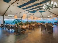 een eetkamer met tafels, stoelen en kroonluchters bij Selectum Colours Bodrum in Gümbet