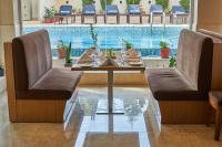 a dining room with a table and a swimming pool at Hotel Crowne Imperial in Kathmandu