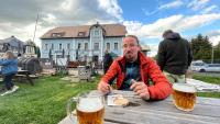 a man sitting at a table with two glasses of beer at Apartmán Lamba Klínovec in Loučná pod Klínovcem