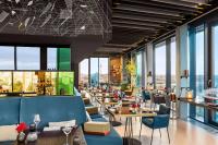 a restaurant with tables and chairs and windows at Vienna House by Wyndham Andel's Berlin in Berlin